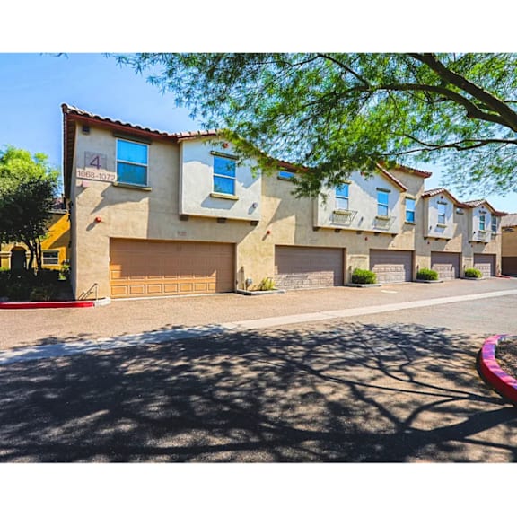 A row of houses with garages and driveways.
