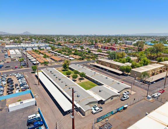A parking lot with a blue truck and a building with graffiti on the side.