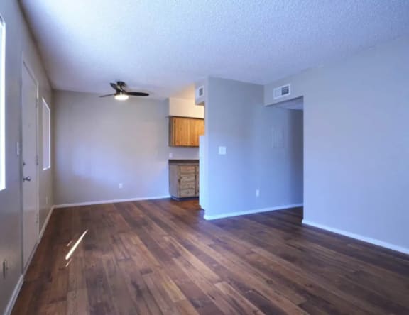 A room with wooden floors and a ceiling fan.