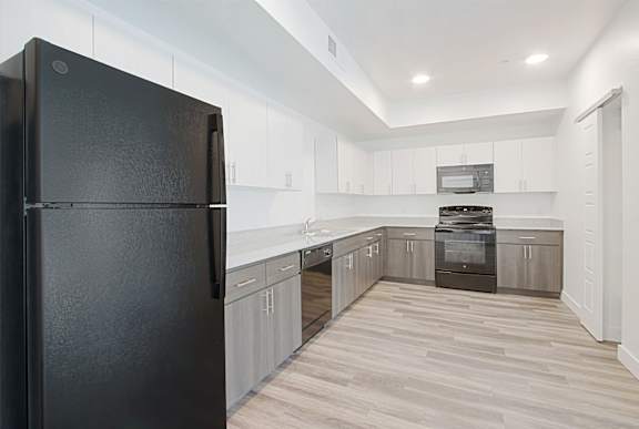a kitchen with white cabinets and a black refrigerator a kitchen with white cabinets and a black refrigerator at 2051 Apartments, Prescott, AZ