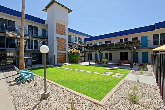 A courtyard with a white lamp post and a green bench.