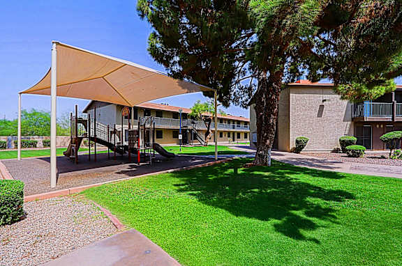 A playground area with a swing set and a canopy.