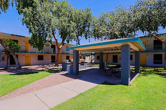 A building with a yellow door and a green lawn in front.