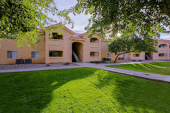 A building with a green lawn in front.
