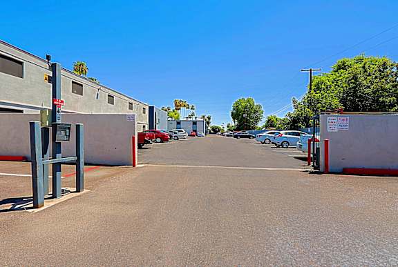 A parking lot with cars parked and a building on the left.