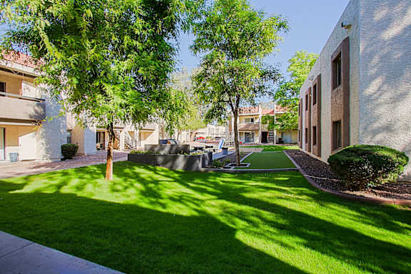 A sunny day in a residential area with apartment buildings and green lawns.