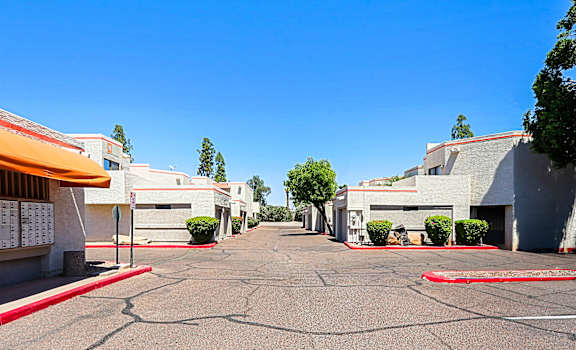 A sunny day at the parking lot of a building complex.