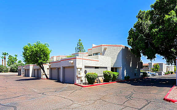 A parking lot in front of a building with a red line painted on the ground.