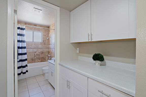 A white bathroom with a toilet, sink, and shower.
