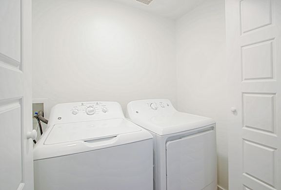 a washer and dryer in a laundry room with white walls a washer and dryer in a laundry room with white walls at 2051 Apartments, Arizona, 86301