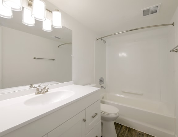 A white bathroom with a sink, toilet, and bathtub.
