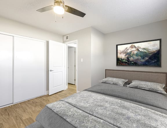 A bedroom with a large bed and a painting on the wall.