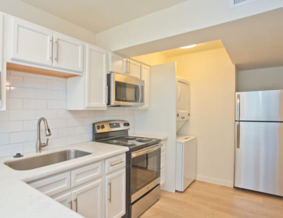 A kitchen with white cabinets and stainless steel appliances.