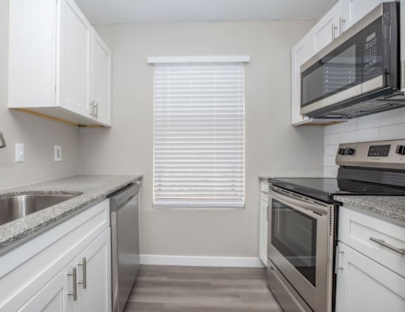 A kitchen with white cabinets and stainless steel appliances.