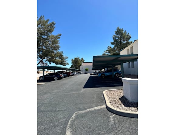 A parking lot with cars and a building in the background.
