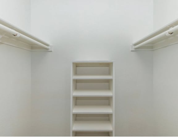 A white shelving unit in a white room.