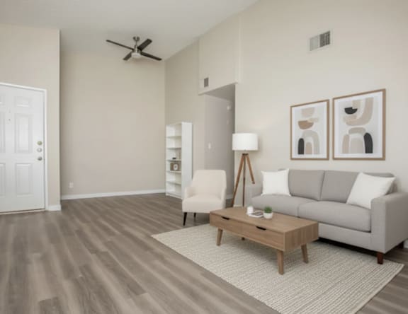 A living room with a grey couch, a wooden coffee table, and a white chair.