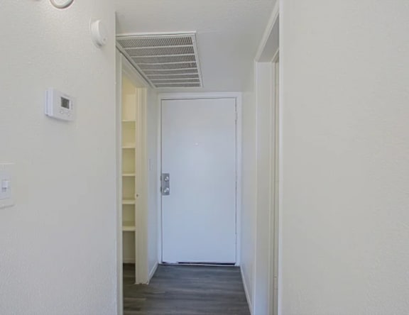 A white door is at the end of a hallway.