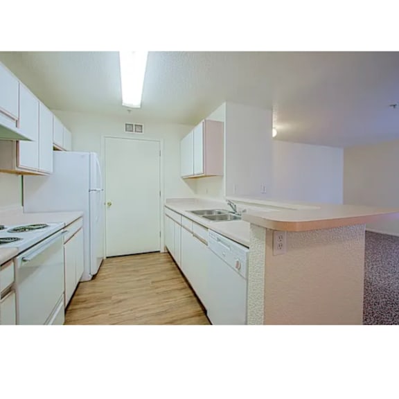A kitchen with white appliances and cabinets.