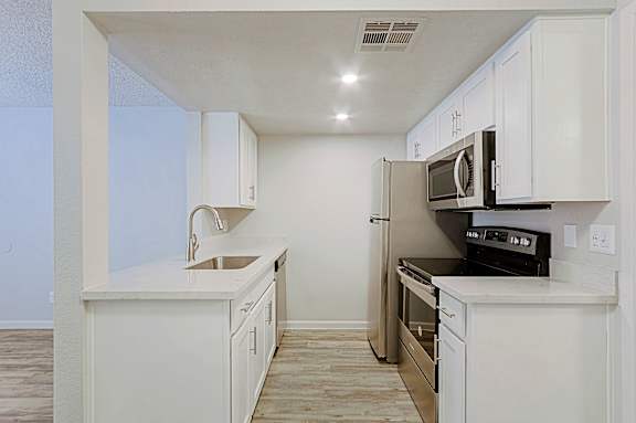 A kitchen with white cabinets and appliances.