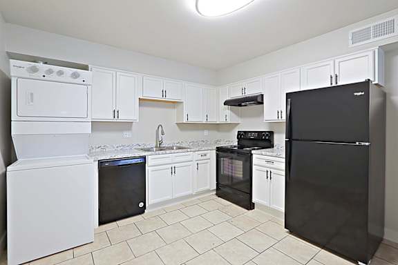 A kitchen with black appliances and white cabinets.