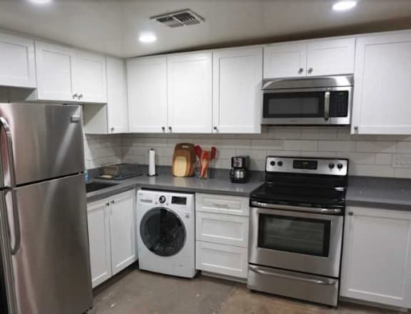 A kitchen with white cabinets and stainless steel appliances.