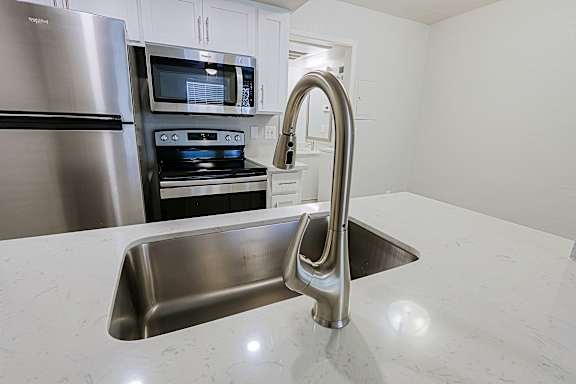 A kitchen with a stainless steel refrigerator, microwave, and oven.
