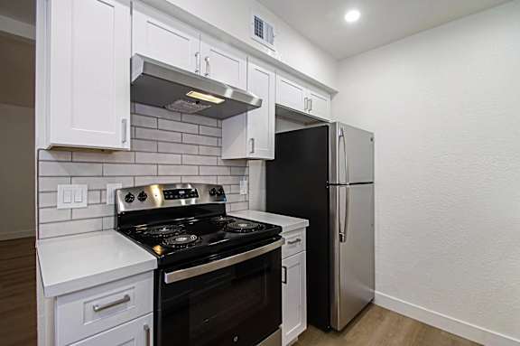 A kitchen with a black stove top oven and a black refrigerator.