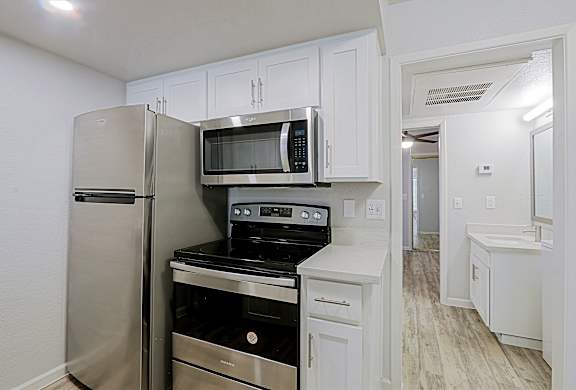 A kitchen with white cabinets and stainless steel appliances.