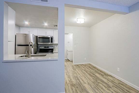 A kitchen with a refrigerator, microwave, and oven.