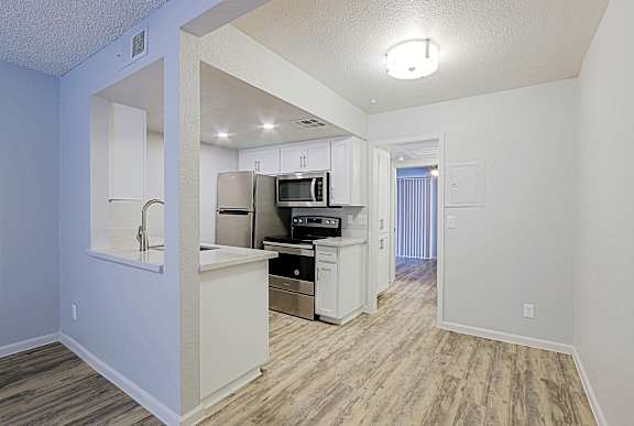 A kitchen area with a refrigerator, microwave, oven, and sink.