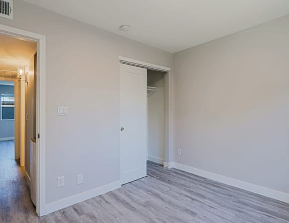 A room with a white door and a grey floor.