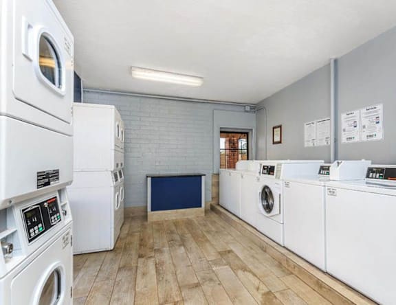A laundry room with a row of washing machines.
