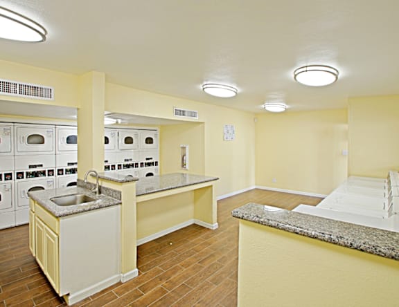 A kitchen with a sink, stove, and oven.