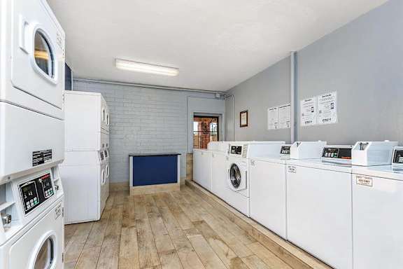 A laundry room with a washer and dryer on the left and a washing machine on the right.