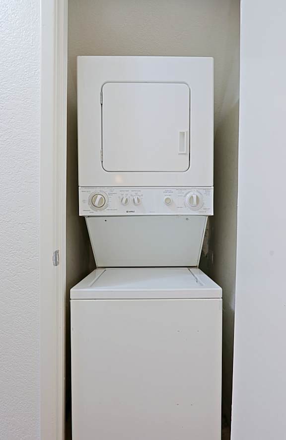 A white dishwasher is built into a white wall.