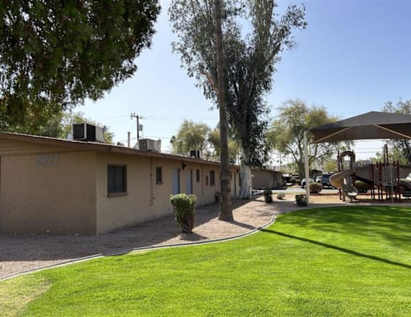 A row of houses with a green lawn in front.