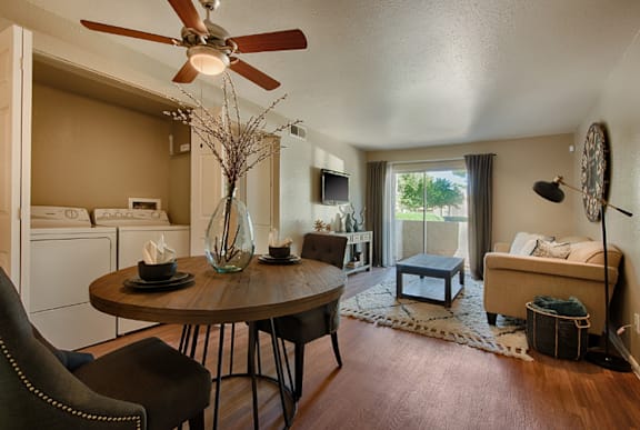 A living room with a brown table and a ceiling fan.