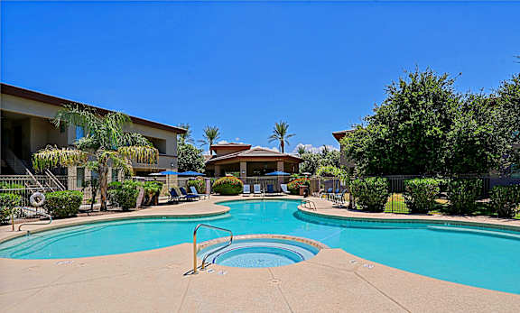 A swimming pool surrounded by a fence and trees.