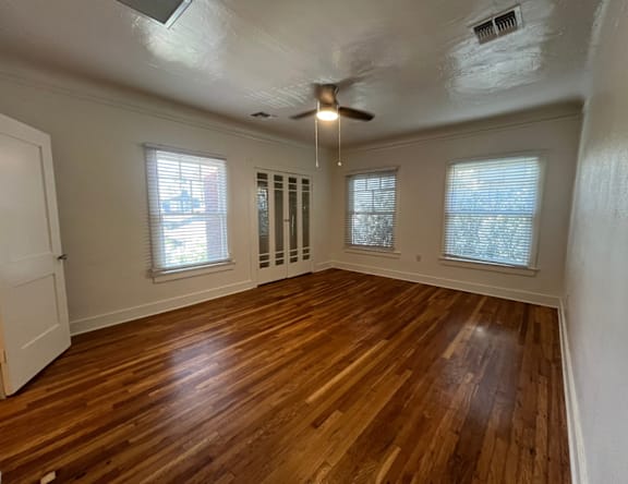 A room with wooden floors and a ceiling fan.
