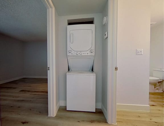 A white washing machine is in a small room.
