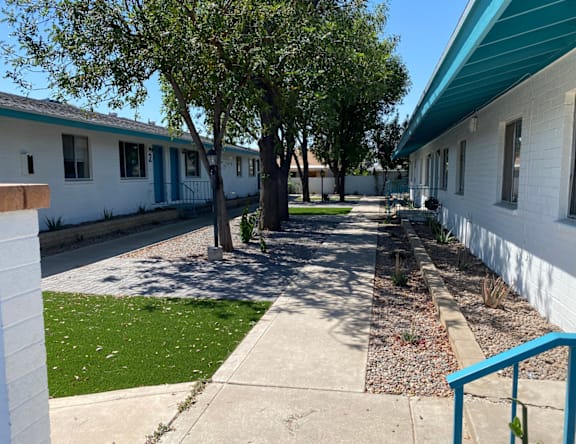 A row of white houses with blue trim and doors.