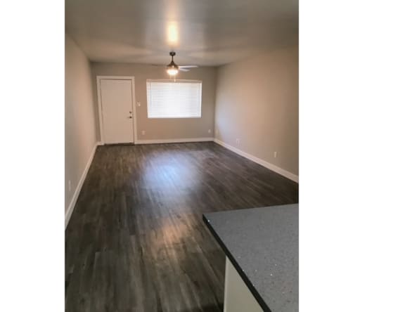 A room with a ceiling fan and a window with blinds.