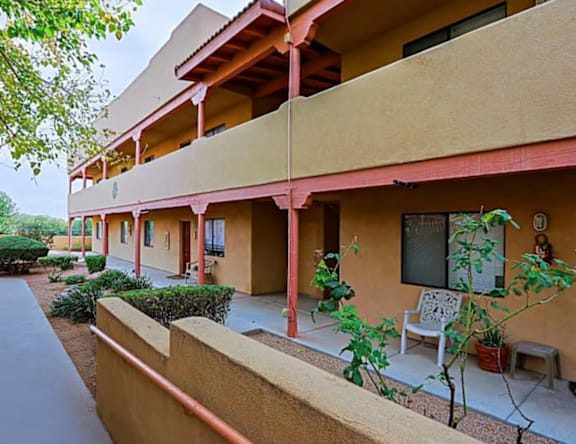 A building with a red railing and a white chair on the balcony.