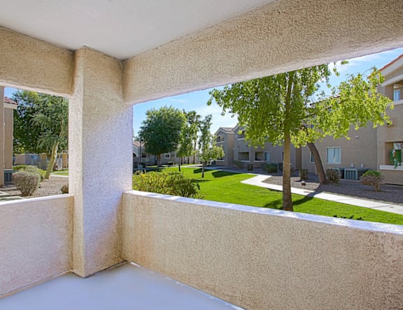 A view from a window looking out at a tree and apartment buildings.