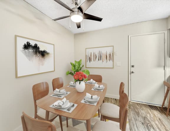 A dining room with a table set for six and two framed pieces of art on the wall.