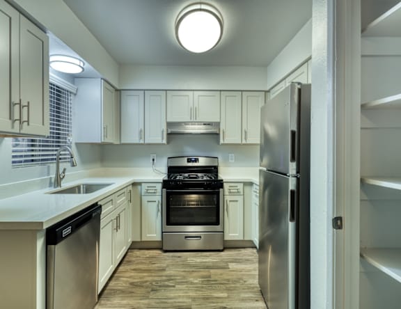 A modern kitchen with a refrigerator, sink, and oven.