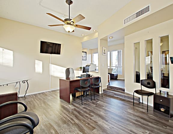 A living room with a television, a fireplace, and a ceiling fan.