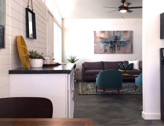A living room with a grey couch and a yellow throw pillow.