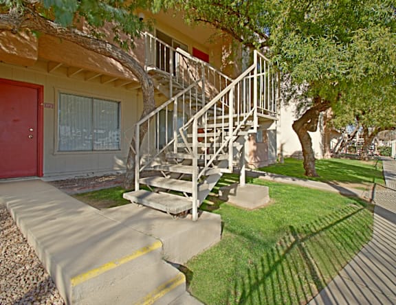 A house with a red door and a staircase leading to the front door.